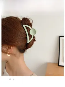 Détail d'une pince à cheveux mate vert menthe pour un chignon élégant sur un modèle