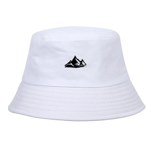 Gros plan de la broderie de montagne noire sur le chapeau bob en toile blanche robuste