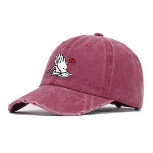 Close-up of vintage washed burgundy baseball cap with rose and hands embroidery