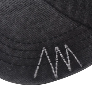 Macro shot of cotton twill fabric and white embroidery details on the black cap brim