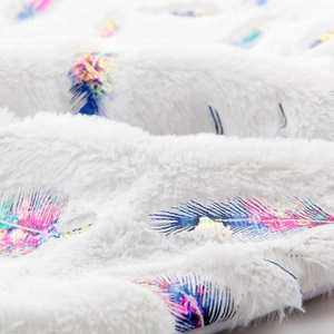 White plush Christmas tree skirt featuring gold feather prints and soft faux fur texture