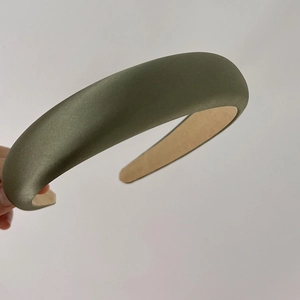 Detail of olive green sponge headband with a glossy silk texture and wide vintage design