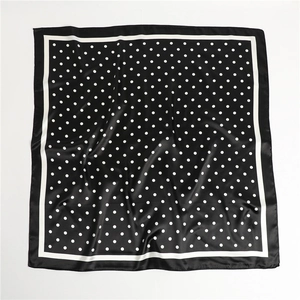 Detail showing the smooth satin texture and elegant polka dot pattern on the silk-like scarf