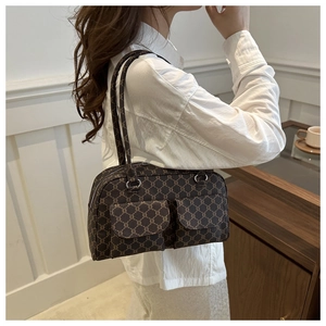 Detailed side view of brown monogram baguette bag on model with vintage wall background