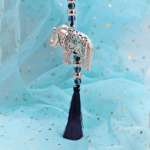 Detailed view of silver elephant pendant with blue evil eye beads and soft silk tassel