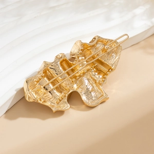 Detailed view of the wavy liquid metal texture and secure back clip of the gold hair pin