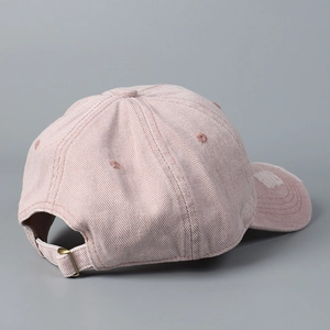 Close-up of pink distressed cotton baseball cap with adjustable strap and metal buckle