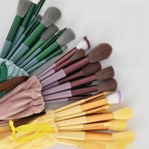 Detail of makeup brush set in green, purple, and yellow with matching drawstring bags