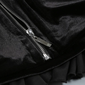 Détail d'une fermeture éclair argentée sur velours noir avec ourlet en tulle plissé