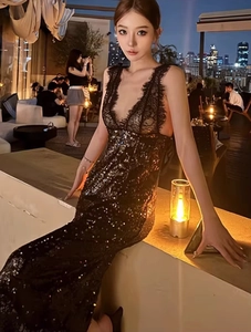 Détail de la robe noire à paillettes avec décolleté en V profond et bordure en dentelle