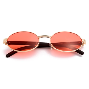 Detalle de las gafas de sol UV400 con lentes naranjas, montura dorada y grabado GV7007