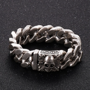 Close-up of vintage silver Cuban chain bracelet featuring a detailed skull clasp design