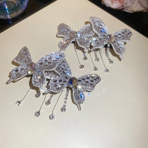 Detail of silver butterfly hair clip with shimmering rhinestones and crystal tassels