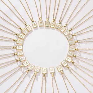 Golden 26 alphabet initial necklaces with white rectangular pendants in a circular layout