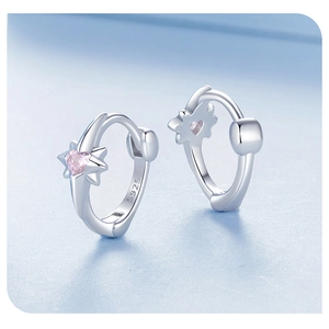 Macro shot of S925 sterling silver hoop earrings with star and pink heart gems