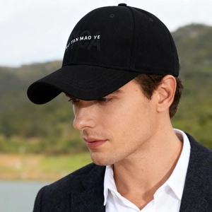 Casual black cotton baseball cap with letter embroidery worn by model in outdoor setting