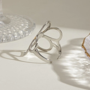 Detailed view of silver open ring with minimalist hollow butterfly design on beige background