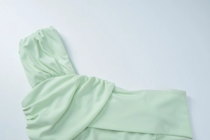 Détail du tissu froncé vert menthe avec une texture plissée élégante sur une robe d'été