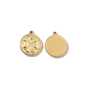 Detailed macro of golden four-leaf clover and smooth round stainless steel pendants