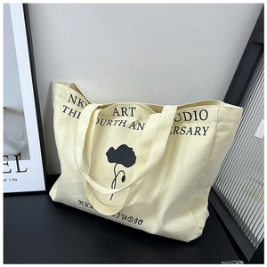 Detailed view of canvas tote bag with black floral art and minimalist typography design