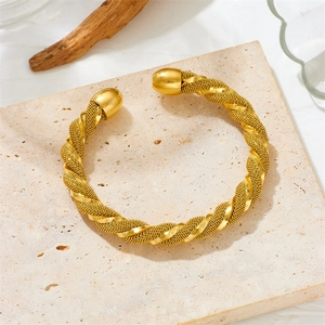 Gold C-shaped titanium steel cuff bracelet with braided texture on a stone base