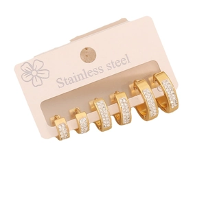 Three pairs of gold stainless steel hoop earrings set with crystal rhinestones on pink card