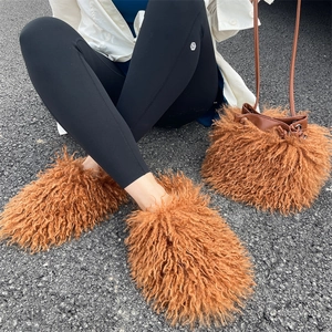 Close-up of fluffy brown faux wool drawstring bucket bag and matching plush boots