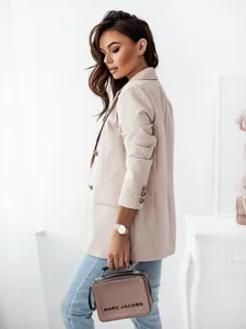 Detail of light beige double-breasted blazer showing brown buttons and slim fit tailoring