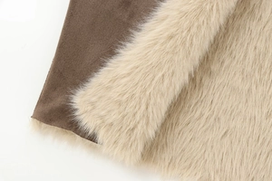 Close-up of premium cream faux fur and dark brown suede texture of a reversible coat