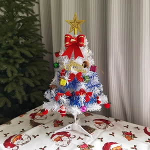 Detail of a white mini Christmas tree decorated with blue tinsel and red bows