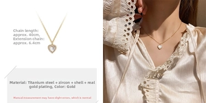 Detailed view of a gold heart pendant with white shell and zircons on a titanium chain