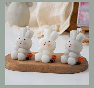 Three rabbit shaped candles with floral details on a wooden tray for home decor