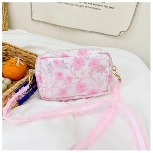 Detail of pink floral sequins and lace strap on a white crossbody bag for girls