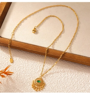 Macro shot of gold-plated stainless steel evil eye pendant necklace with a green zircon