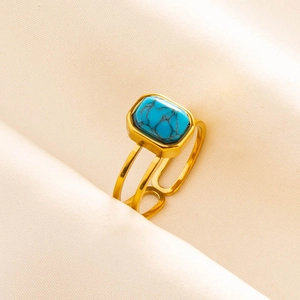 Macro shot of gold stainless steel ring with rectangular blue turquoise in hollow band