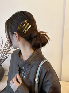 Detailed view of acetate hair clips in tortoiseshell and solid colors on a side hairstyle