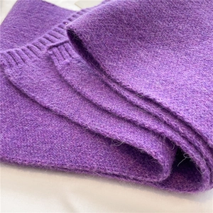 Close-up of soft purple knitted fabric showing detailed plush texture and thick yarn layers