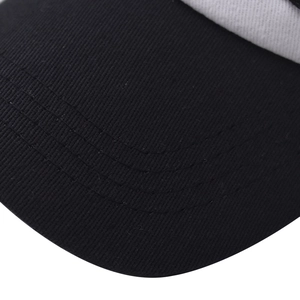 Macro shot of black twill baseball cap visor with four parallel reinforced stitching lines