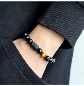 Detail of 8mm black beads bracelet with tiger eye stone and Leo zodiac symbol bead