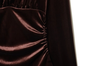 Close-up of ruched dark brown velvet fabric showing rich texture and elegant drapes
