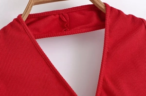 Dettaglio del vestito in maglia rossa che mostra cuciture dello scollo e trama a costine