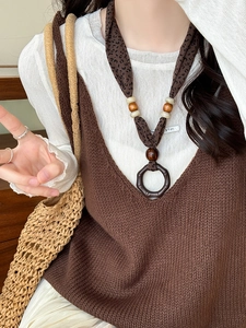 Close-up of ethnic style fabric necklace with wood beads and leopard print pendant