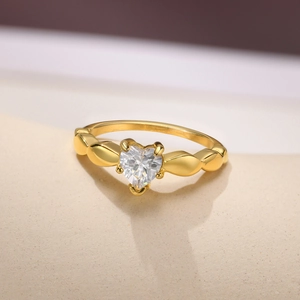 Elegant gold heart shaped gemstone ring with four-prong setting and unique leaf design