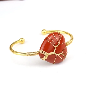 Detail of handmade gold wire-wrapped Tree of Life on heart-shaped red gemstone bangle