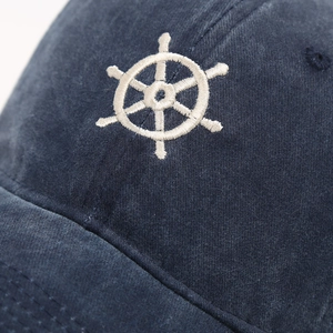 Macro detail of high-quality corduroy fabric with white helm embroidery on a navy baseball cap