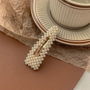 Macro detail of white pearls on a gold BB hair clip with vintage aesthetic setup