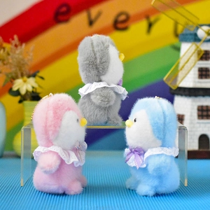 Detailed view of cute plush penguin charms in pink, blue, and grey colors