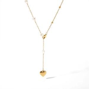 Elegant gold pearl necklace with white heart charms and a large golden heart pendant