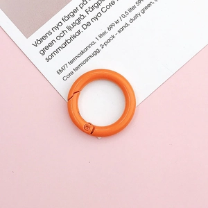Close-up of a 25mm bright orange lacquered metal spring ring for DIY jewelry making