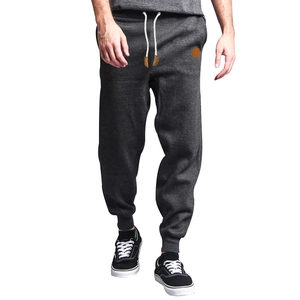 Detail of dark grey joggers featuring elastic drawstring waist and premium cotton texture